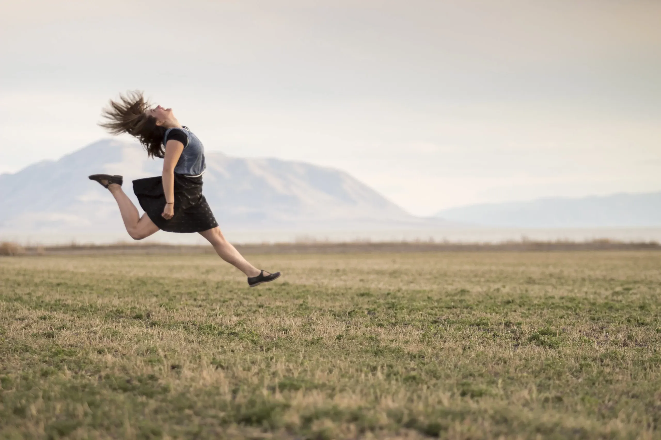 Foto di una ragazza che salta in un campo