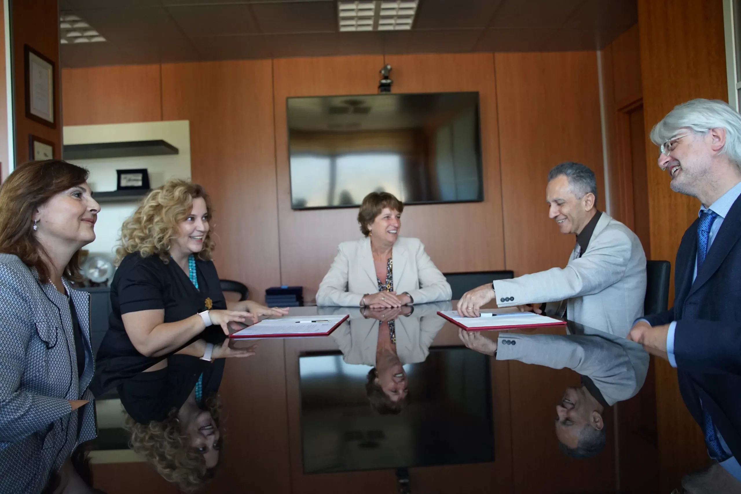 Professori e Professoresse seduti attorno ad un tavolo che discutono