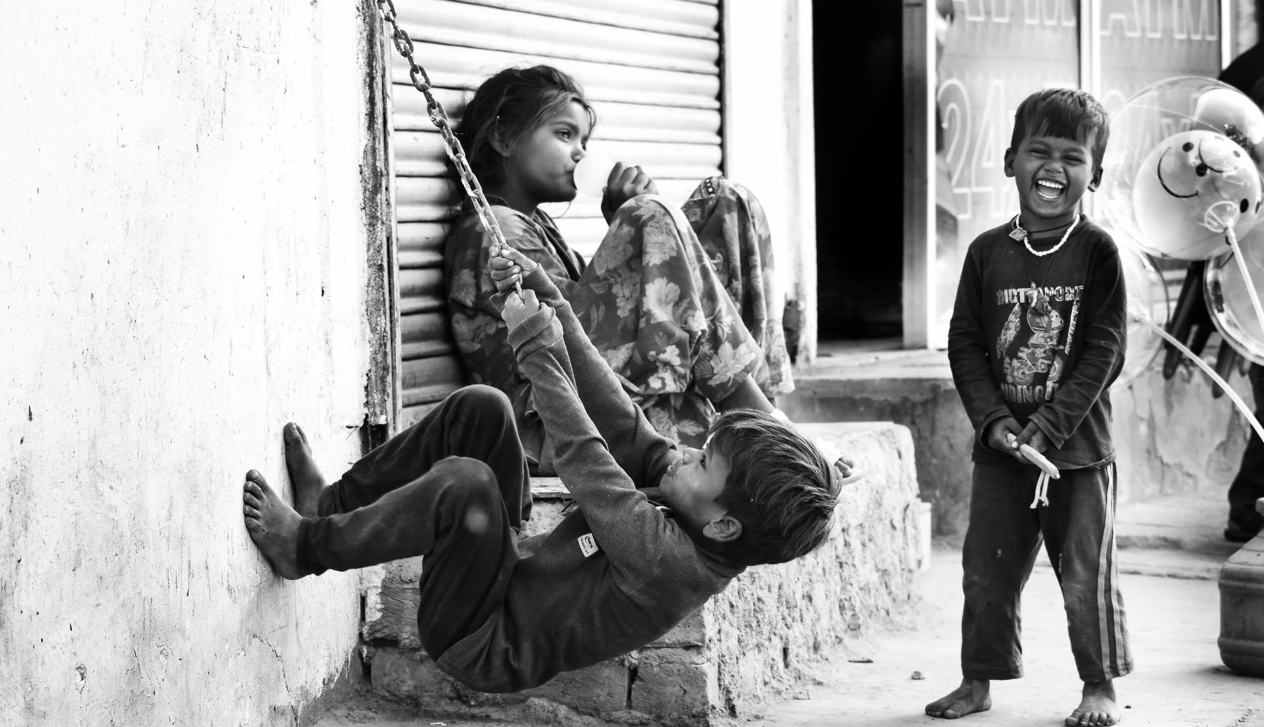 Tre bambini che giocano felici all'aperto.