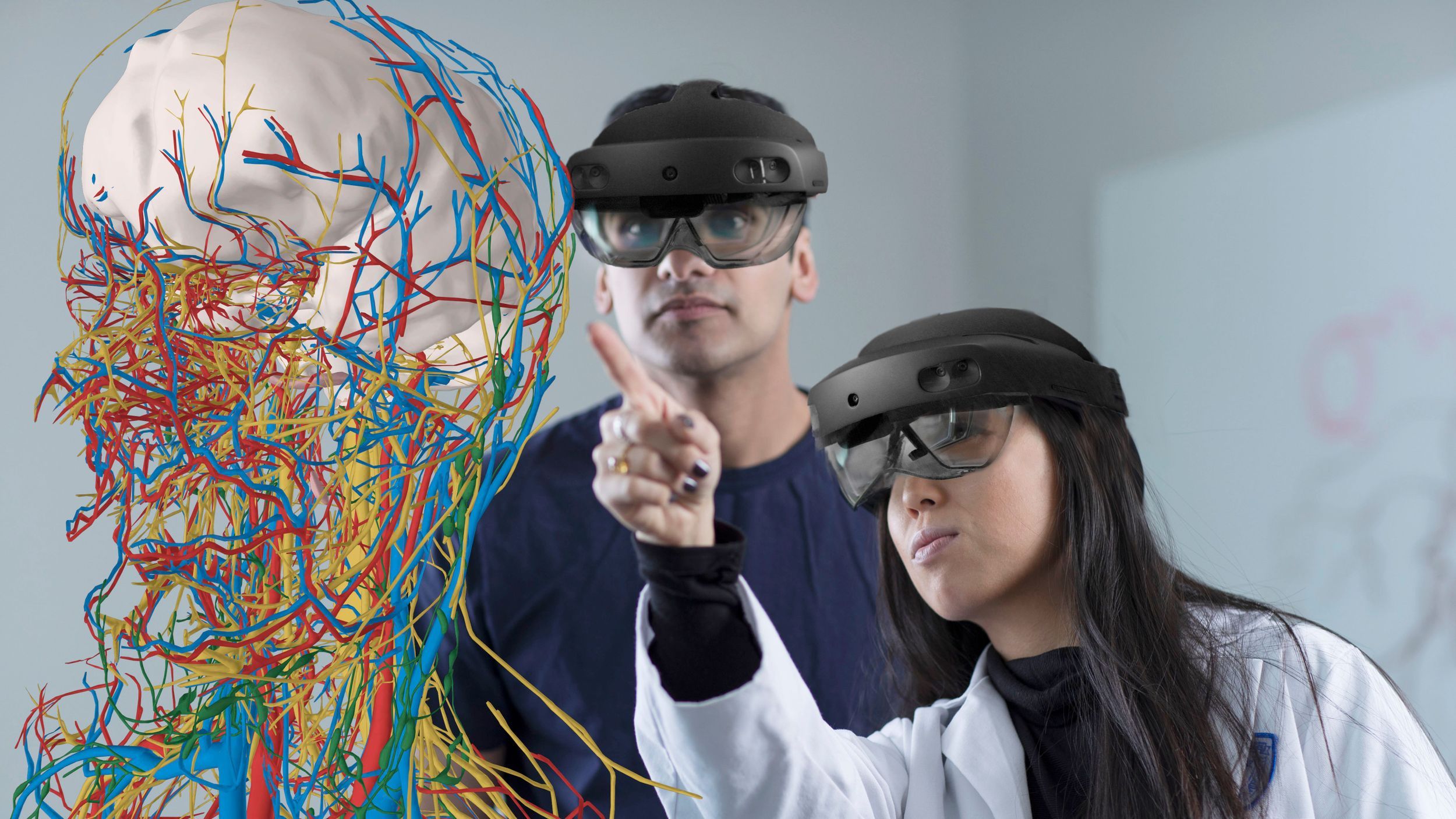 Foto di due ricercatori con visori che studiano il corpo umano