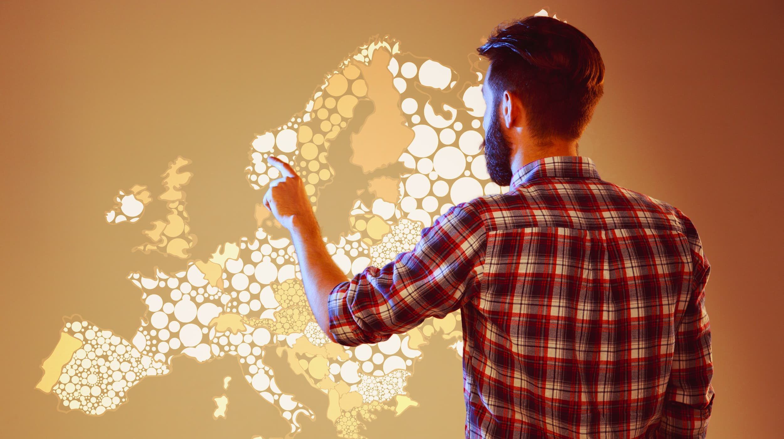Immagine di un uomo in piedi davanti a una mappa digitale e interattiva dell'Europa