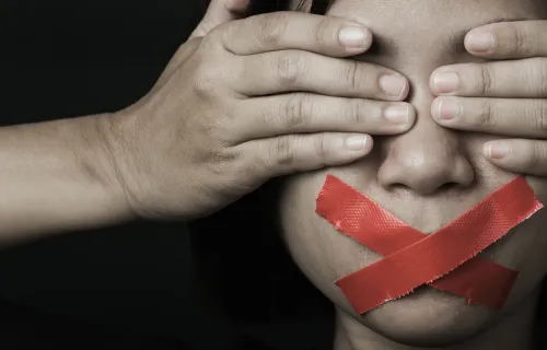 Foto rappresentativa delle violenze di genere, una donna ha occhi coperti e bocca tappata