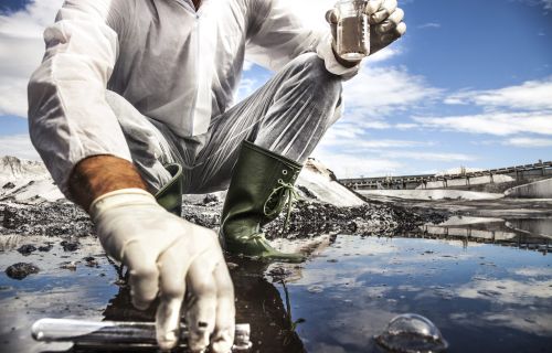 Immagine di un ricercatore che preleva un campione di acqua inquinata