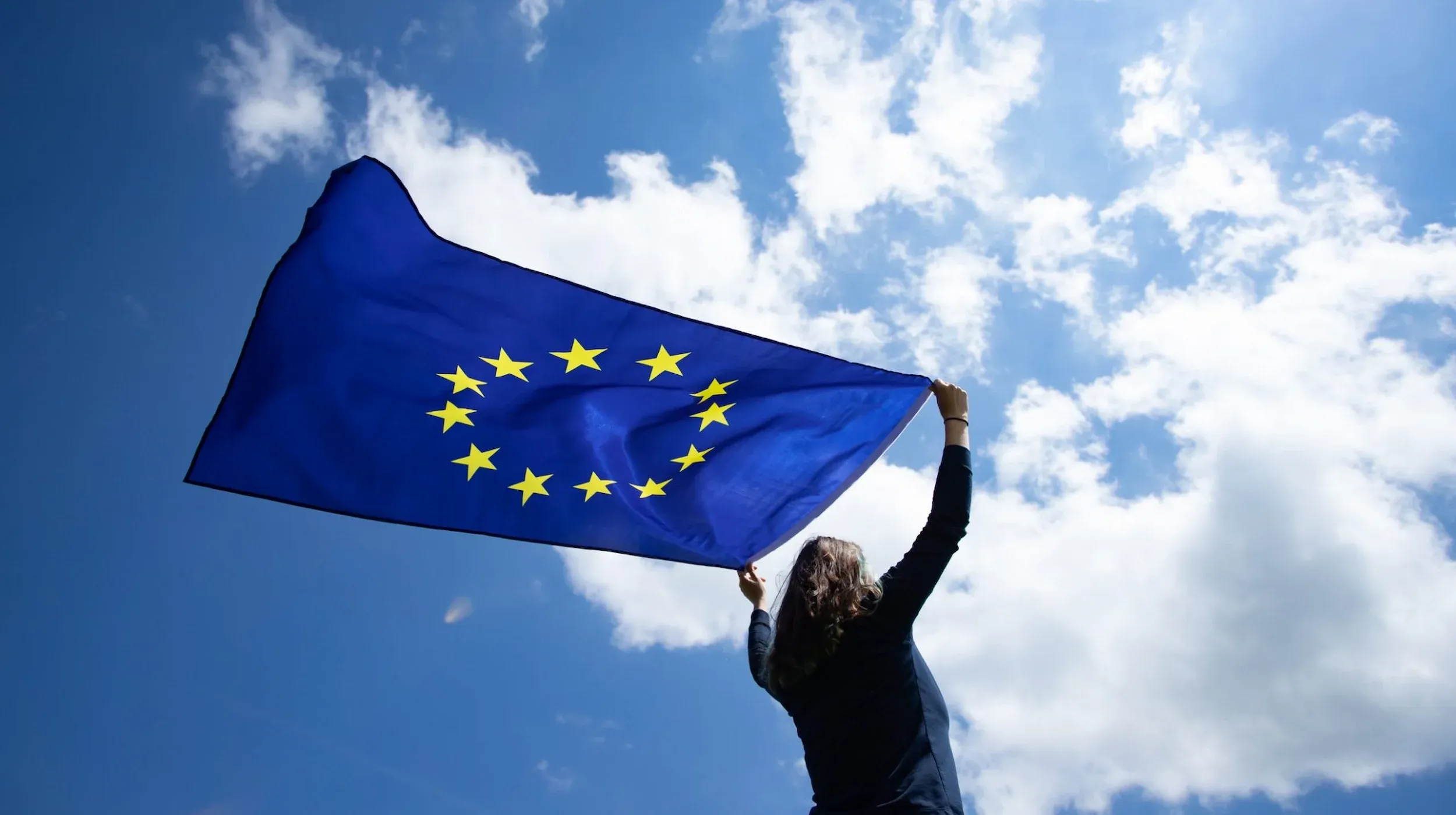 Donna sventola la bandiera dell'Unione Europea