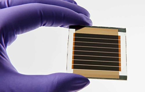 Piccola cella solare tenuta da una mano che indossa un guanto
