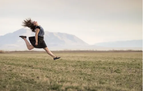Foto di una ragazza che salta in un campo