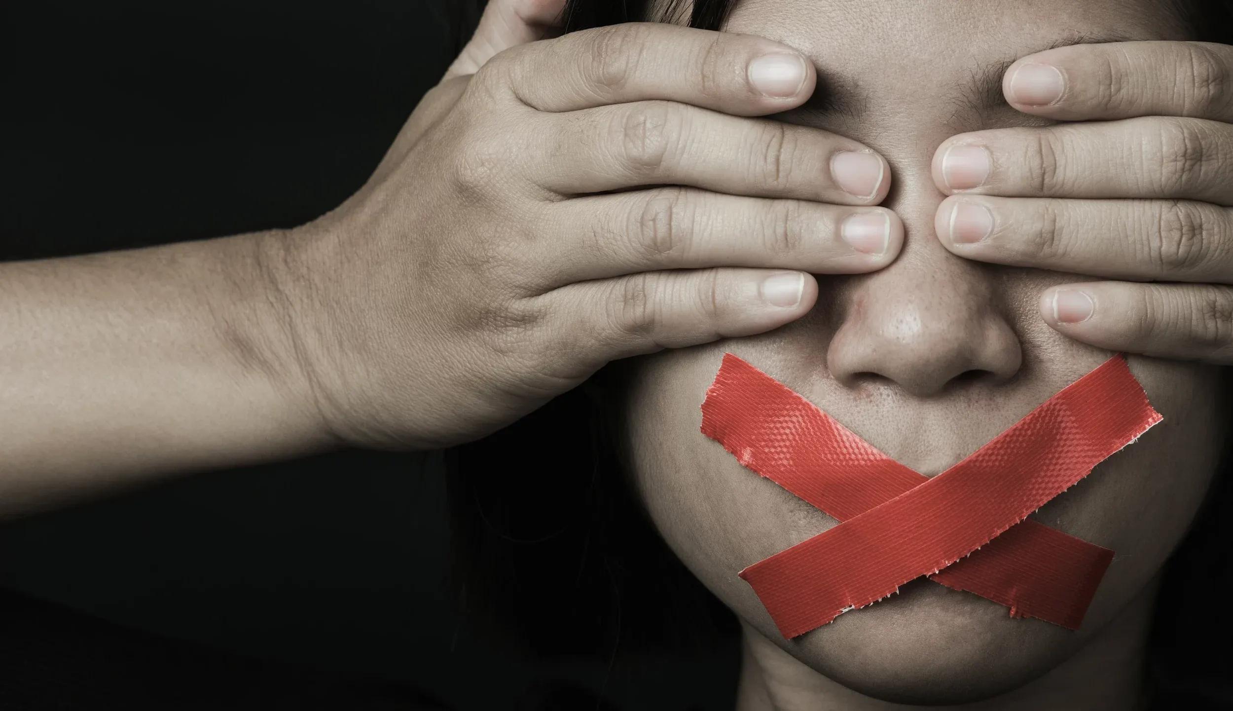 Foto rappresentativa delle violenze di genere, una donna ha occhi coperti e bocca tappata