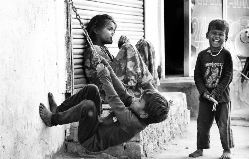 Tre bambini che giocano felici all'aperto.