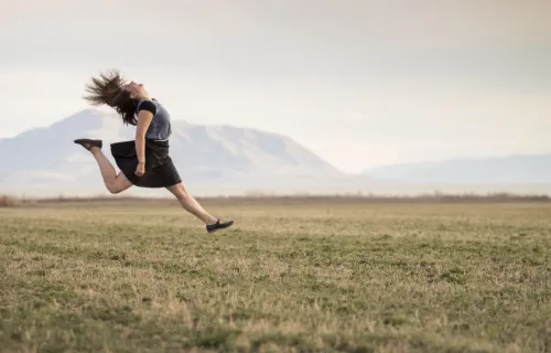Foto di una ragazza che salta in un campo
